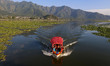 Visitors take a boat ride across the waters of Dal Lake in Srinagar, Jammu and Kashmir, In...
