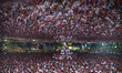 Football fans, predominantly wearing Argentina national team jerseys, gather at an outdoor...