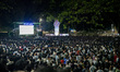 A wide shot captures a large gathering of citizens watching the World Cup final match on a...