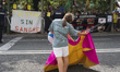 A young bullfighter performs passes with the cape in front of anti-bullfighting activists...