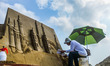 A sculptor creates sand sculptures in Zhoushan City, east China's Zhejiang Province, Aug....