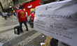 Pedestrians look at job postings on display in downtown Sao Paulo, Brazil, on Wednesday, S...