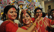 Hindu women apply  sindhur, or vermillion powder, on each others face after worshipping th...
