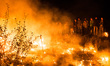 Migrants stand in the Calais Jungle at a burning hut  in Calais, France, on 25 October 201...