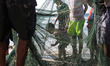 A Palestinian fishermen from Gaza collects his net in Gaza City after fishing off the coas...