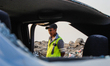 A security forces member inspects the damaged car after an attack with a bomb-laden vehicl...
