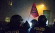A protester holding a banner and policemen face each other during an anti fascist march or...