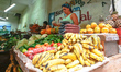 A local woman at her stand selling fruits and vegetables in a  traditional market. A typic...