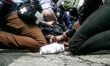Team medic and photographer helping a demonstrator injured by a cop during a protest again...