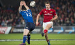 Rory Scannell of Munster kicks the ball over Rory O'Loughlin of Leinster during the Guinne...