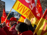 People hold French General Confederation of Labour (CGT) union's flags and a banner during an inter-union protest to alert on a plan of mass...