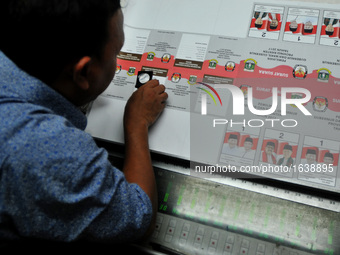 Printing worker checks ballot papers prepared for the provincial elections throughout Indonesia to come in a printing company in Pulogadung,...