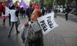 A woman holds a flag saying In Spanish Peña Out at a demonstration against Gasoline Shock...