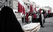 Bahrain , Abu Saiba - women standing holding a bread watching the demonstration ,  demonst...