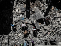 A Palestinian  looks at debris and remains of cars after what police said was an Israeli air strike that destroyed a nearby house in an in G...