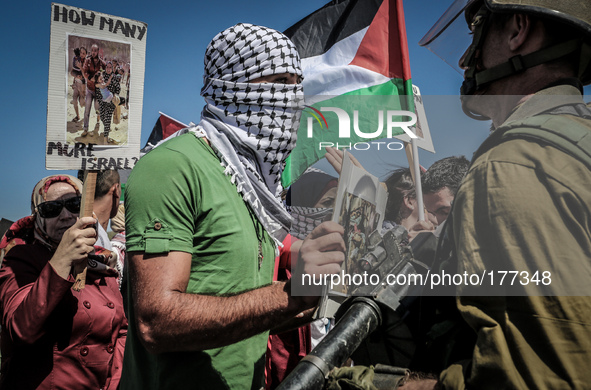 Palestinians hold national flags and pictures of children who were killed in the Israeli attack on the Gaza Strip during a march against the...