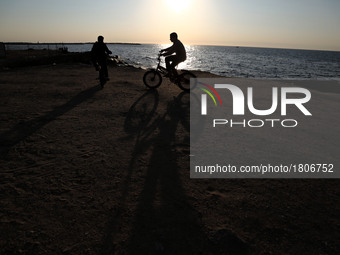  Palestinian boys rides  bicycle during sunset in Gaza City, on March 5, 2017. (
