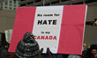 Pro-Muslim protestor carrying a sign saying 'No Room for Hate in My Canada' as opposing gr...