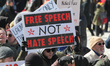 Pro-Muslim protestor carrying a sign saying 'Free Speech NOT Hate Speech' as opposing grou...