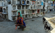 A couple waits for the relatives of the deceased who agreed to pay them 100 pesos per mont...