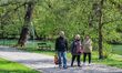 People enjoy hot and sunny weather walking in park near the Barlangfurdo cave bath complex...