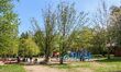 People enjoy hot and sunny weather walking in park near the Barlangfurdo cave bath complex...