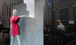 Ten-foot tall "Chicken Don" inflatable chicken is seen reflected in the window of Macy's a...
