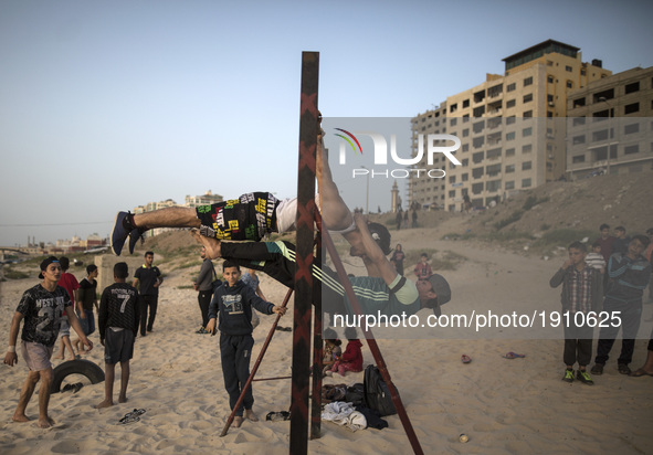 Palestinian youths demonstrate their street workout skills in the beach of Gaza City during Sunset on April 21, 2017. 