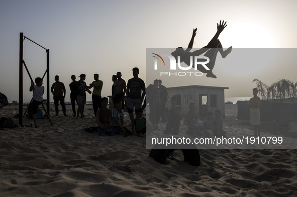 A palestinian youth practice his parkour skills in the beach of Gaza City during Sunset on April 21, 2017. 