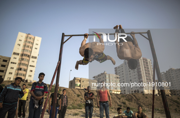 Palestinian youths demonstrate their street workout skills in the beach of Gaza City during Sunset on April 21, 2017.  