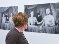 A lady passes in front of photographs 'Sisters' and 'Sisters 2' - by a group of artists  'Lodz Kaliska' - a part of 'Art in Art' new exhibit...