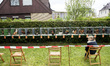 Judges sit in front of cages with roosters to count the number of the crows during a 'Roos...