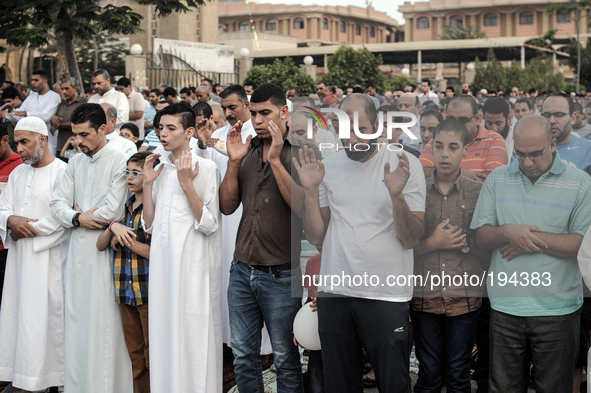 People attend Eid al-Fitr prayers with their Families outside a mosque in Giza July 28, 2014. Eid al-Fitr marks the end of the Muslim holy m...