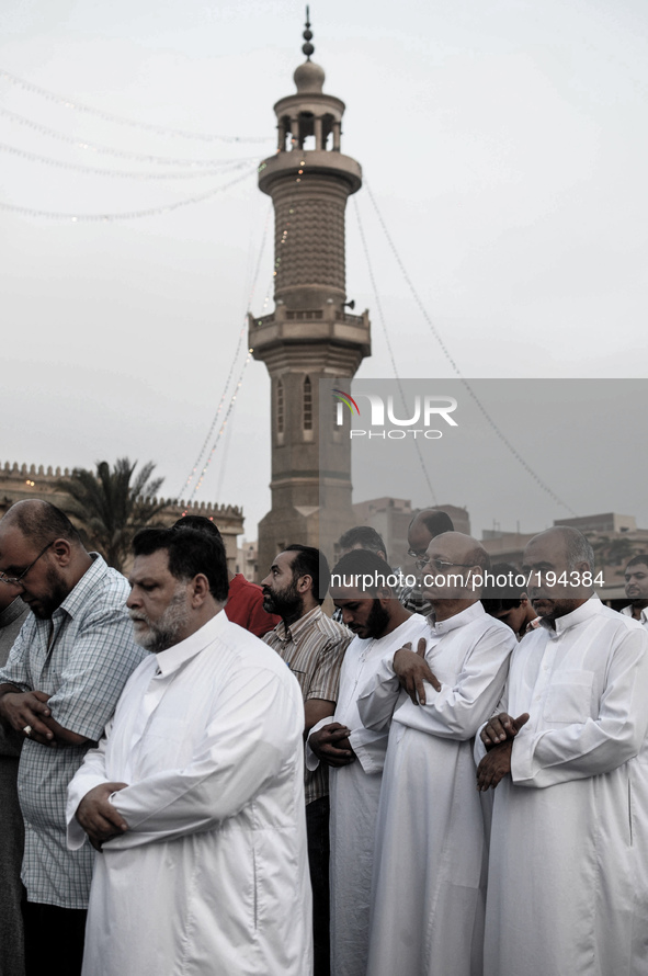 Pople attend Eid al-Fitr prayers with their Families outside a mosque in Giza July 28, 2014. Eid al-Fitr marks the end of the Muslim holy mo...