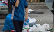 A boy covers his nose with his hand to ward off the stench of garbage during the fourth da...