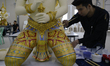 Thai official painters work on a deity sculpture which will be used to decorate the royal...