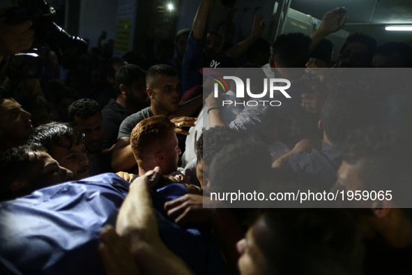 Palestinian mourners carry the body of fisherman Mohammed Majed Bakr, 25, outside a hospital morgue in Gaza City, on May 15, 2017. An Israel...