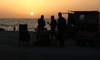 A Palestinian street vendor sells corn to a customer at a stand on the beachfront in Gaza...