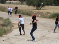 A Palestinian protester throws a stone at Israeli soldiers during clashes at a protest in support of Palestinian prisoners on hunger strike...
