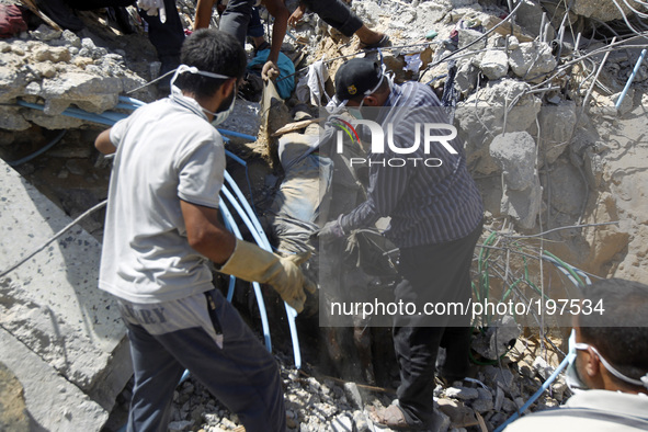 Palestinian rescue workers remove the body of a dead man from under the rubble of the Duheir family home which was destroyed in an Israeli a...