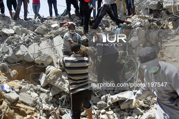 Palestinian rescue workers remove the body of a dead man from under the rubble of the Duheir family home which was destroyed in an Israeli a...