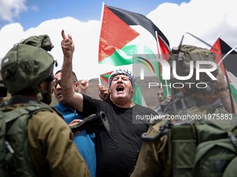 Palestinian protesters argue with Israeli soldiers during a protest in support of Palestinian prisoners on hunger strike in Israeli jails, a...