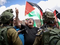 Palestinian protesters argue with Israeli soldiers during a protest in support of Palestinian prisoners on hunger strike in Israeli jails, a...