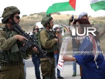 A Palestinian woman argue with Israeli soldiers during a protest in support of Palestinian prisoners on hunger strike in Israeli jails, at I...