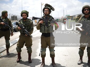Israeli soldiers watching Palestinian protesters during a protest in support of Palestinian prisoners on hunger strike in Israeli jails, at...