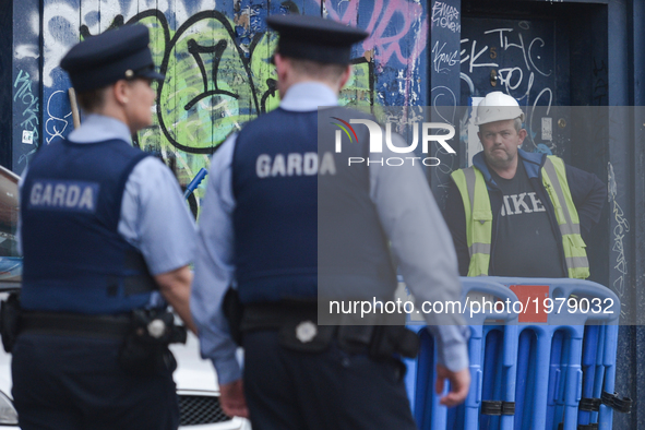 Two Garda officers passe by a construction worker standing outside a construction site, in Dublin's city center.
On Wednesday, May 24, 2017,...