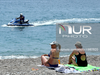 Two woman on the seaside looking to a jet sky patrolling the coast at Taormina, Italy on May 25, 2017.
Leaders of the G7 group of nations,...