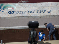  cleaners in action before world leaders arrive at the stage to pose for a photo group ahead the G7 summit in Taormina, on May 26, 2017. (
