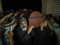 Relatives of Coptic Christians who were killed during a bus attack, surround their coffins, during their funeral service, at Ava Samuel dese...