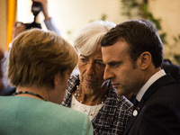French Prime Minister Emmanuel Macron (R), head of the International Monetary Fund (IMF) Christine Lagarde (C) and German Chancellor Angela...